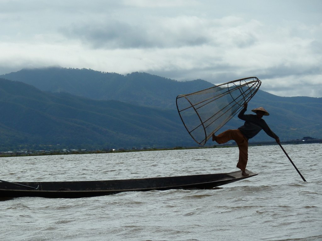 Fischerman poses with his cone shape fishing net